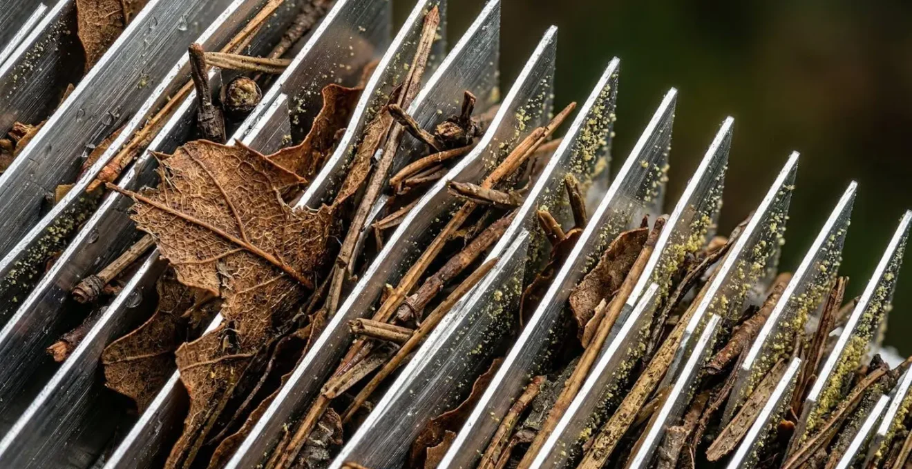 Gros plan sur ailettes d'évaporateur de pompe à chaleur encrassées par feuilles et pollen